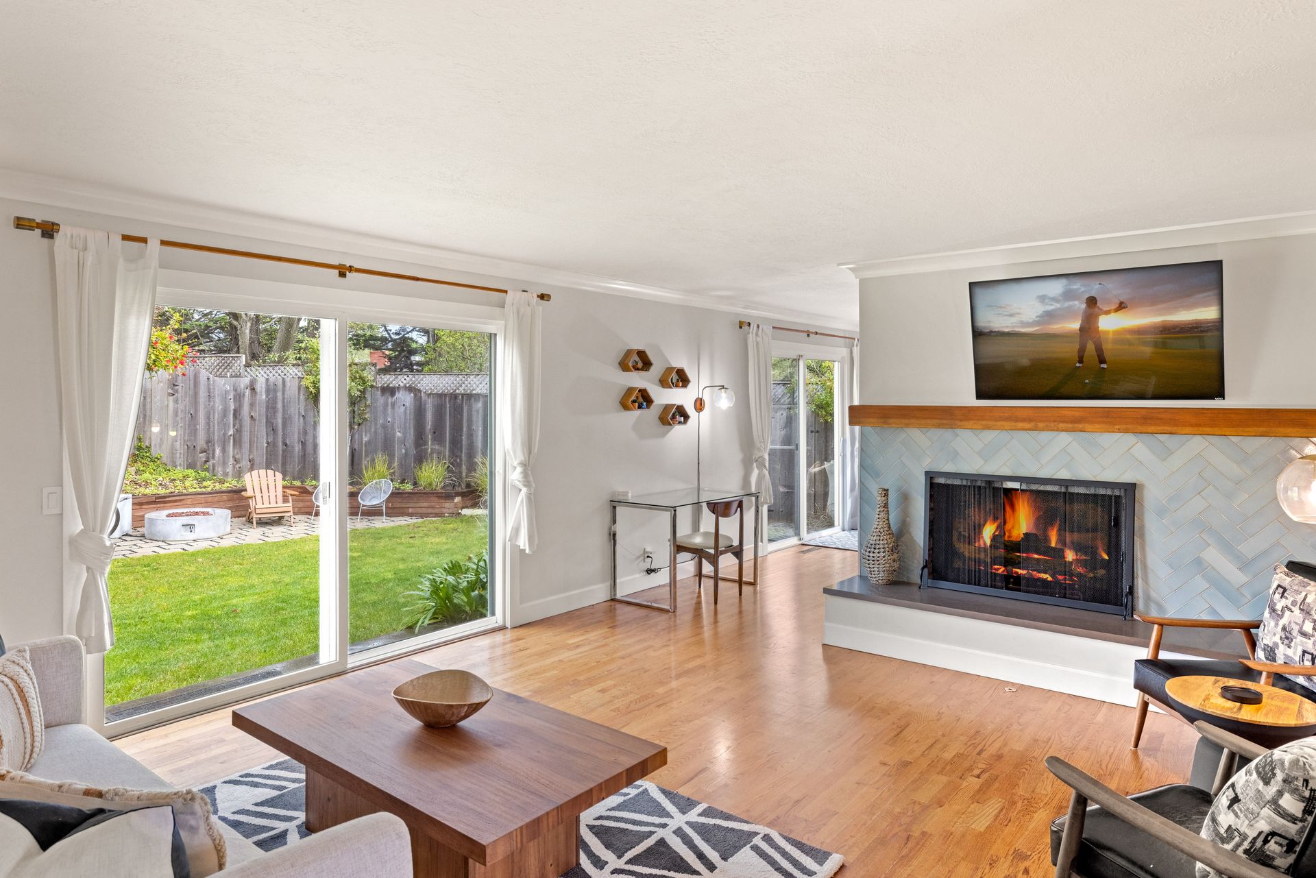A living room with a fireplace and a flat screen tv.