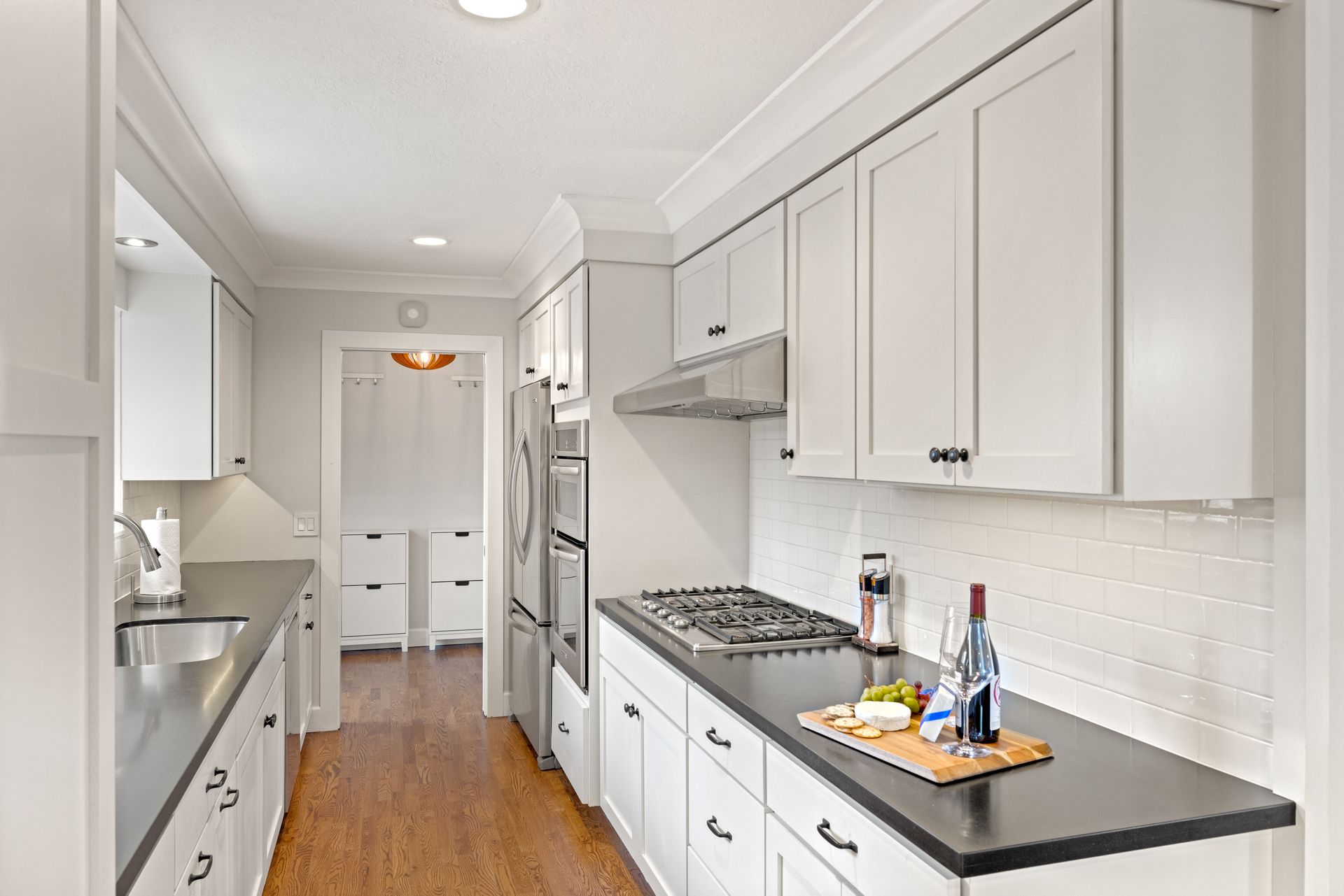 A kitchen with white cabinets and black counter tops