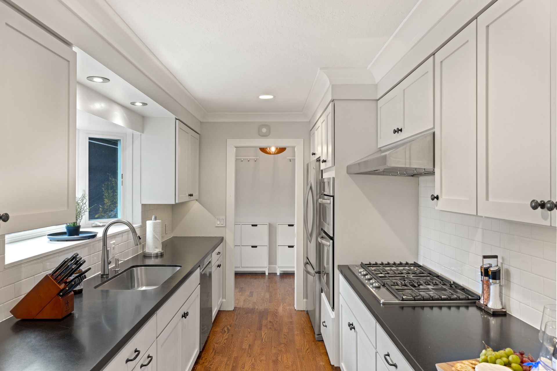 A kitchen with white cabinets and black counter tops
