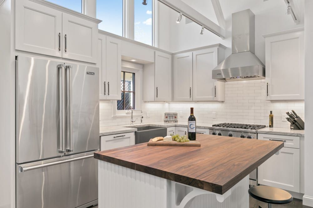 A kitchen with stainless steel appliances and a wooden counter top.