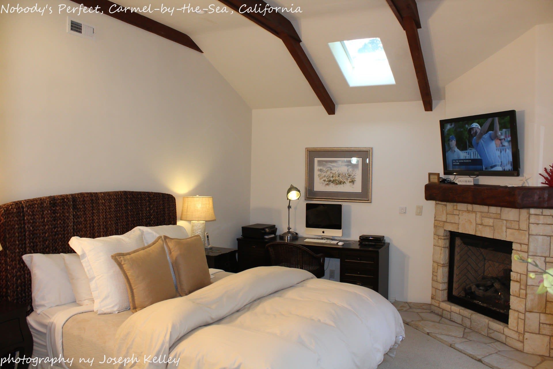 A bedroom with a large bed and a fireplace