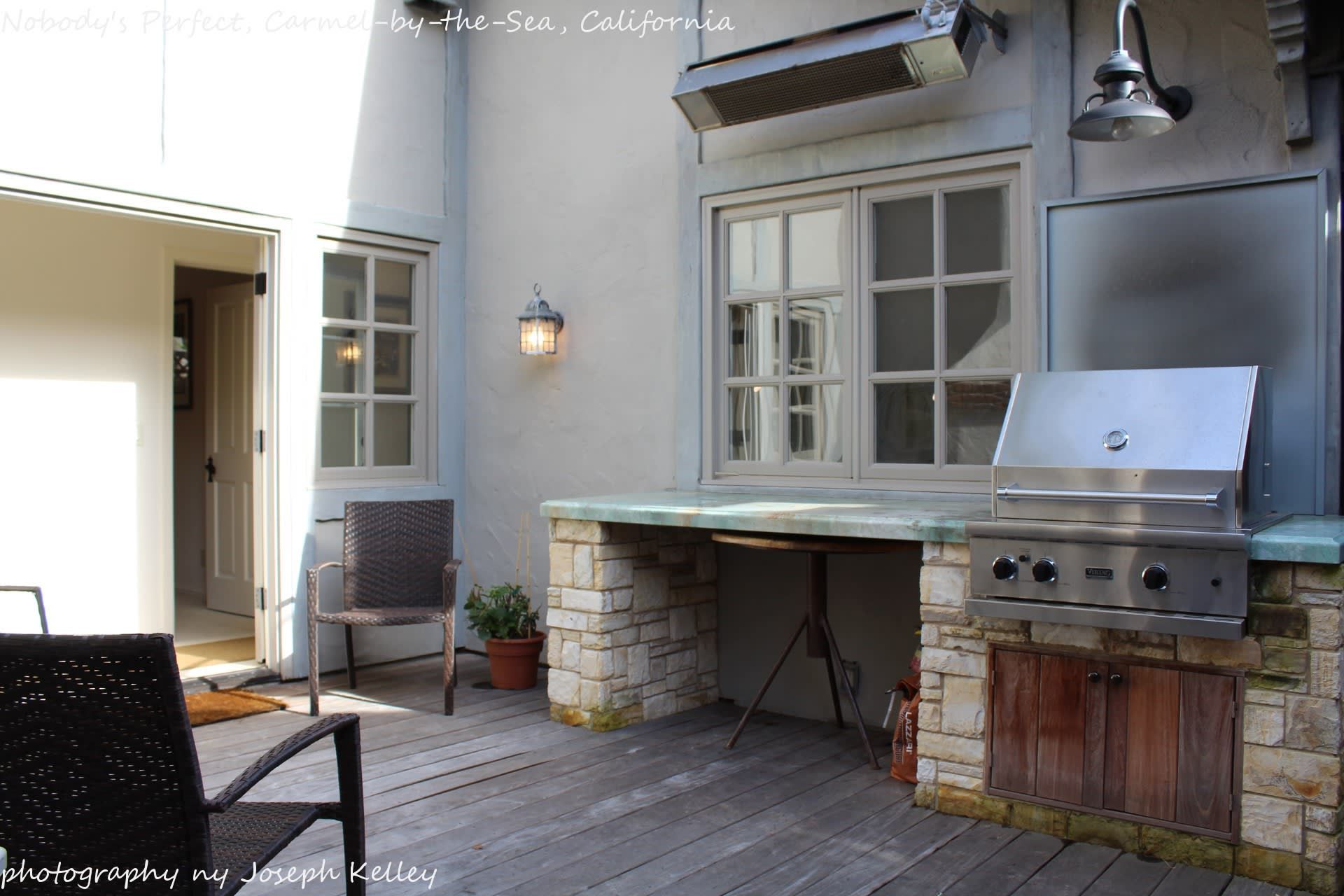 A patio with a grill and chairs in california