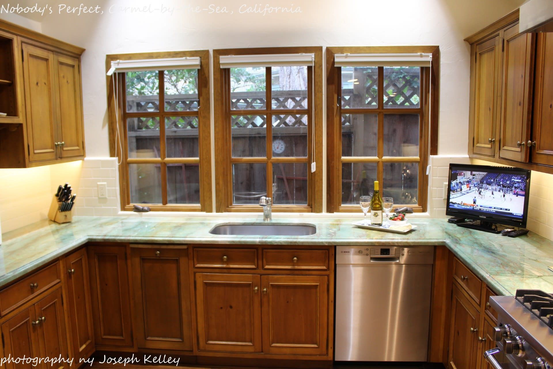 A kitchen with wooden cabinets and a stainless steel dishwasher