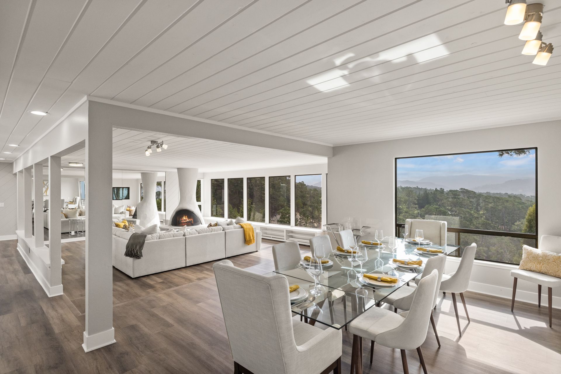 A large living room with a dining table and chairs and a fireplace.