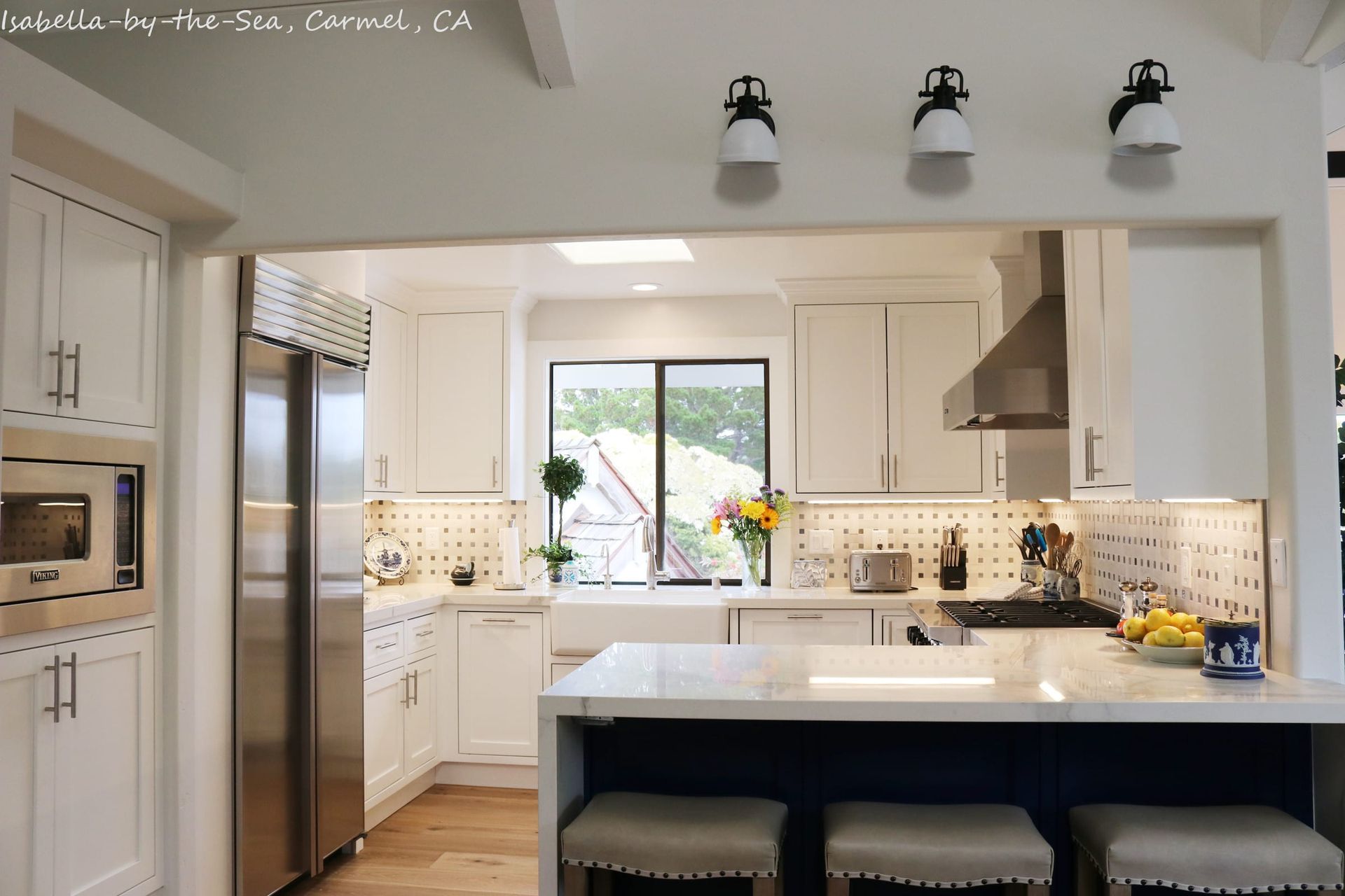 A kitchen with white cabinets and stainless steel appliances