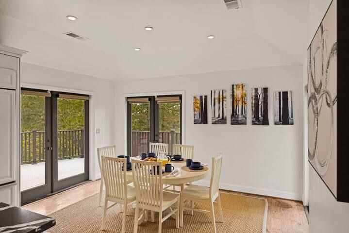 A dining room with a table and chairs and sliding glass doors.