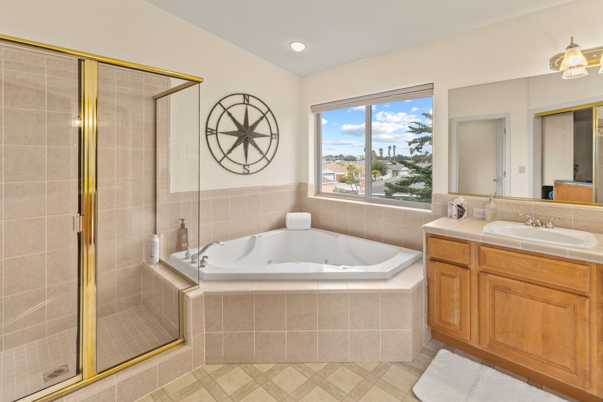 A bathroom with a jacuzzi tub , sink , and shower.
