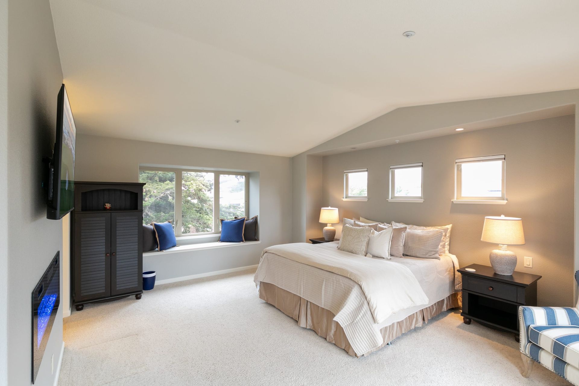 A bedroom with a king size bed and a fireplace.