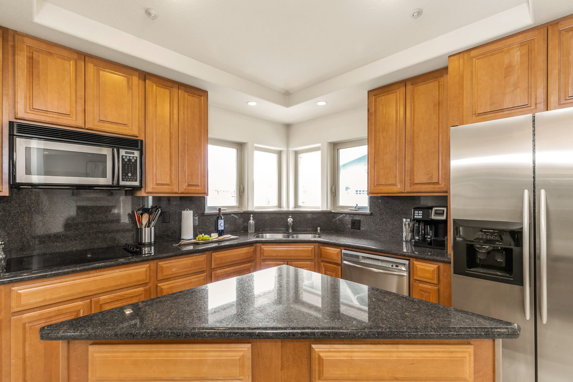 A kitchen with stainless steel appliances and granite counter tops.