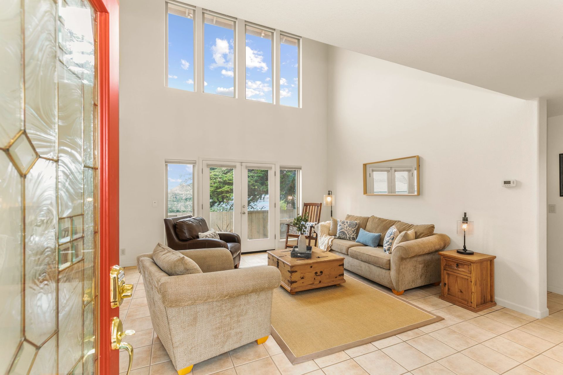 A patio with wicker furniture and a fire pit in front of a house