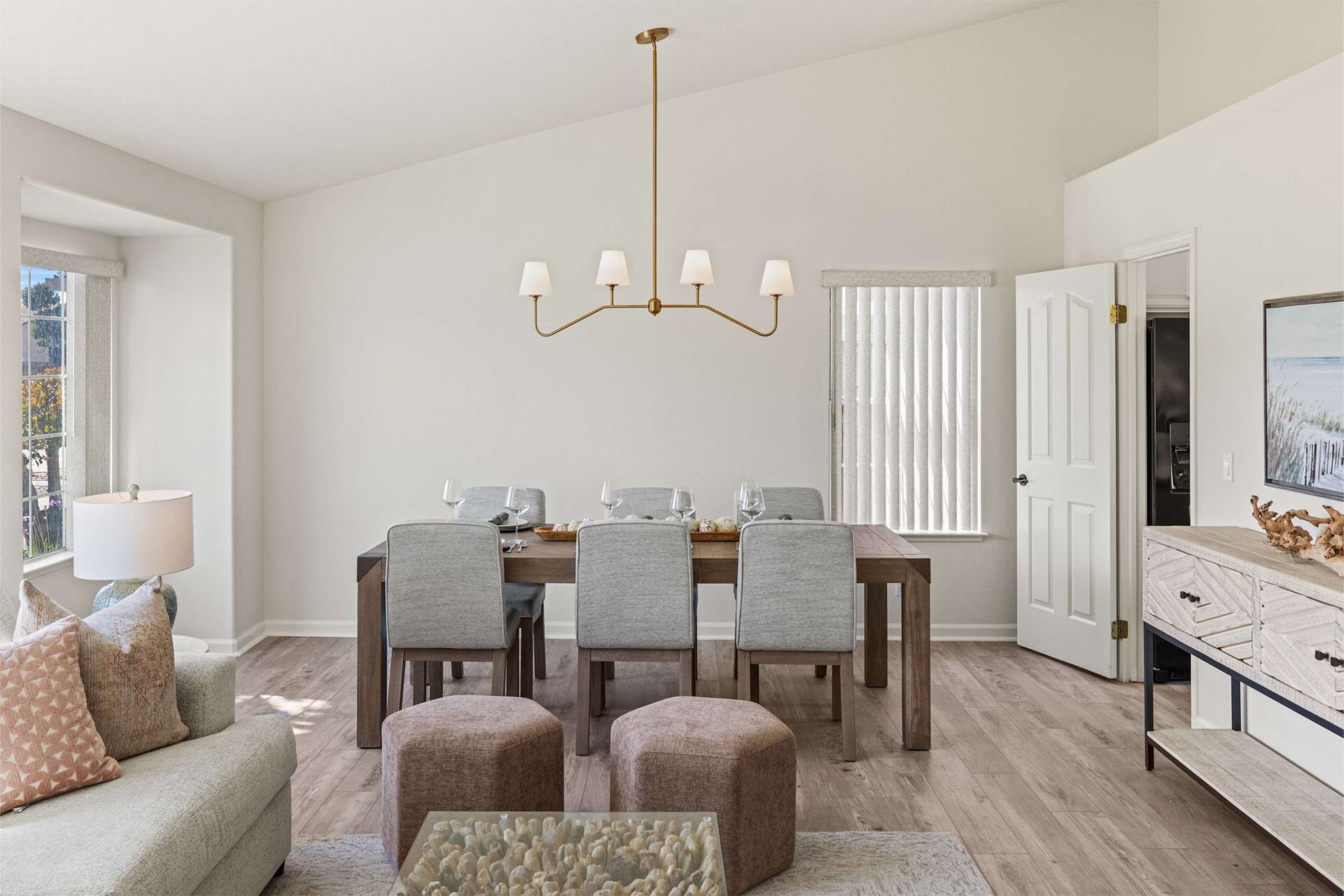 A living room with a dining table and chairs and a chandelier.