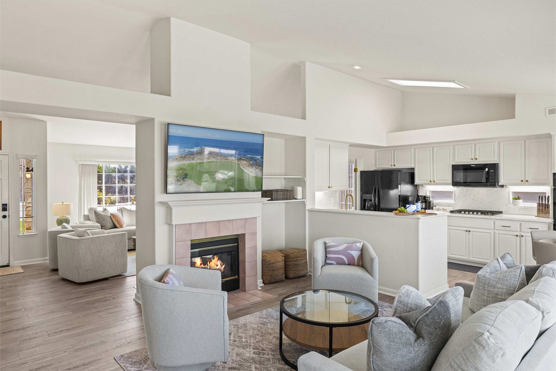 A living room with a couch , chairs , a fireplace and a flat screen tv.