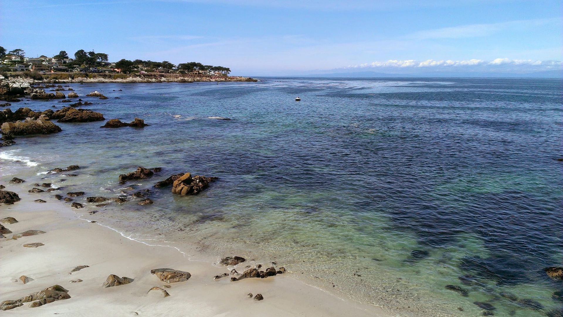 A beach with a lot of rocks in the water