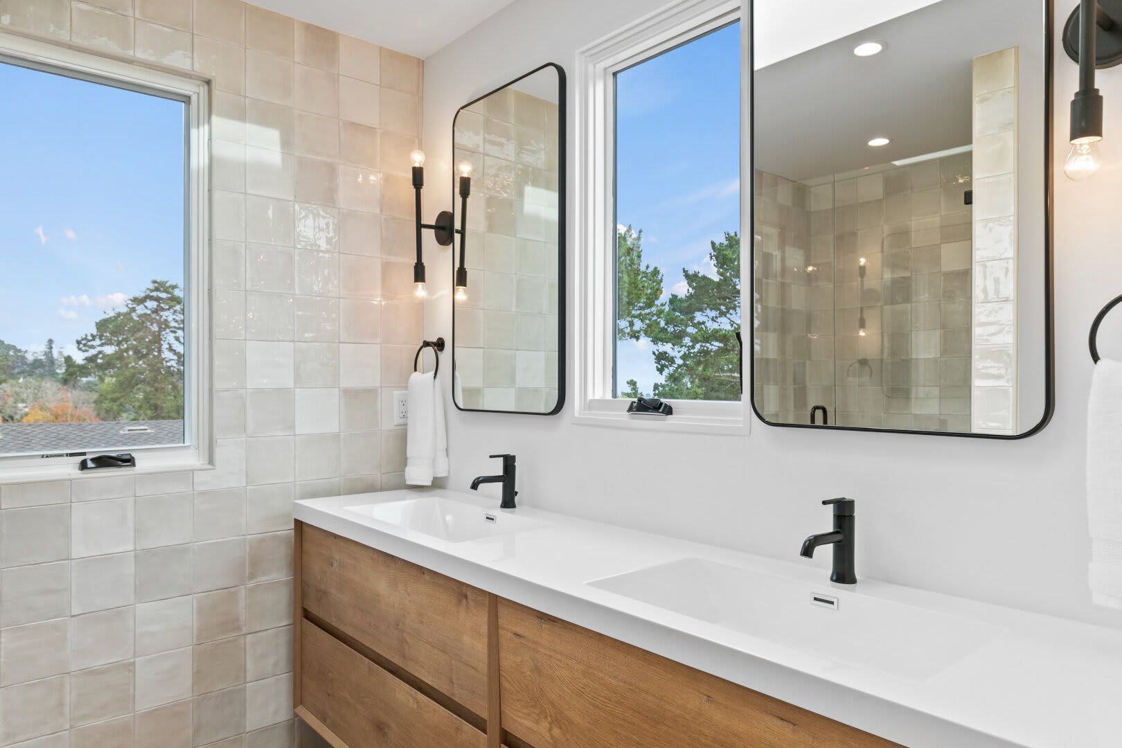 A bathroom with two sinks and three mirrors.