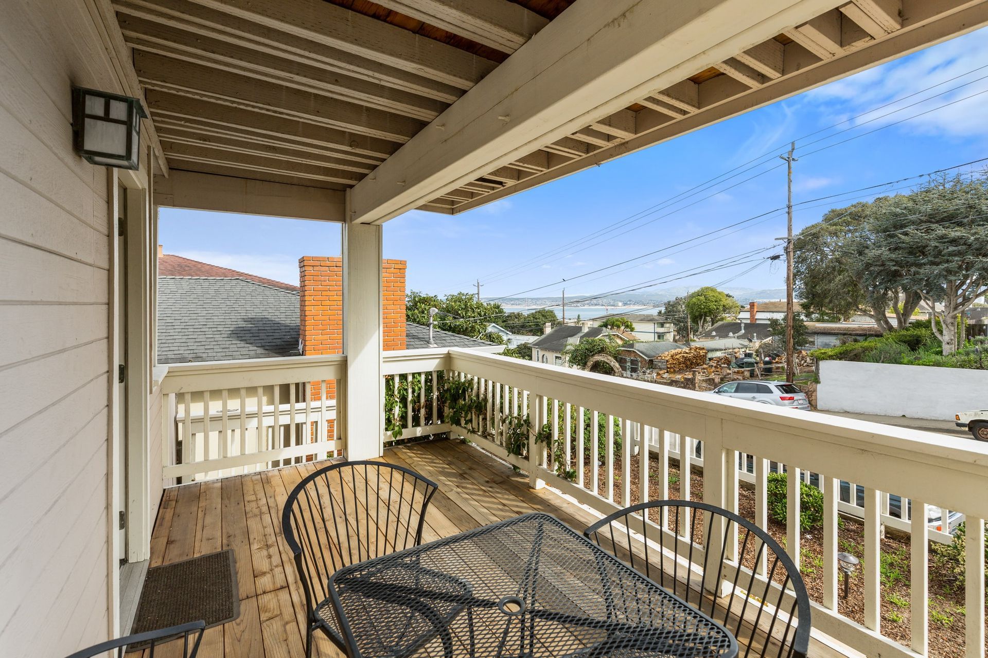 A balcony with a table and chairs and a view of the ocean.