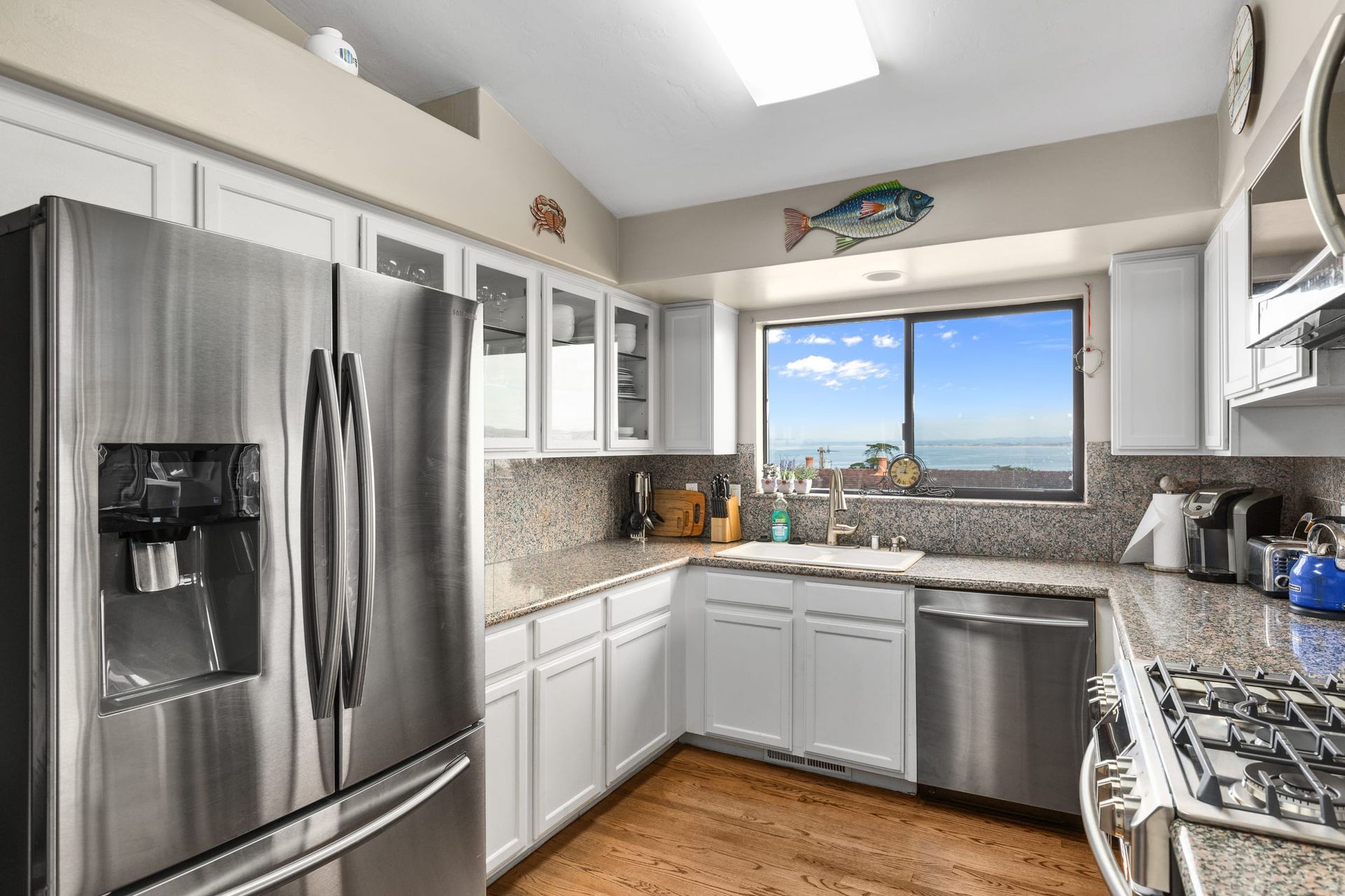 A kitchen with stainless steel appliances and white cabinets.