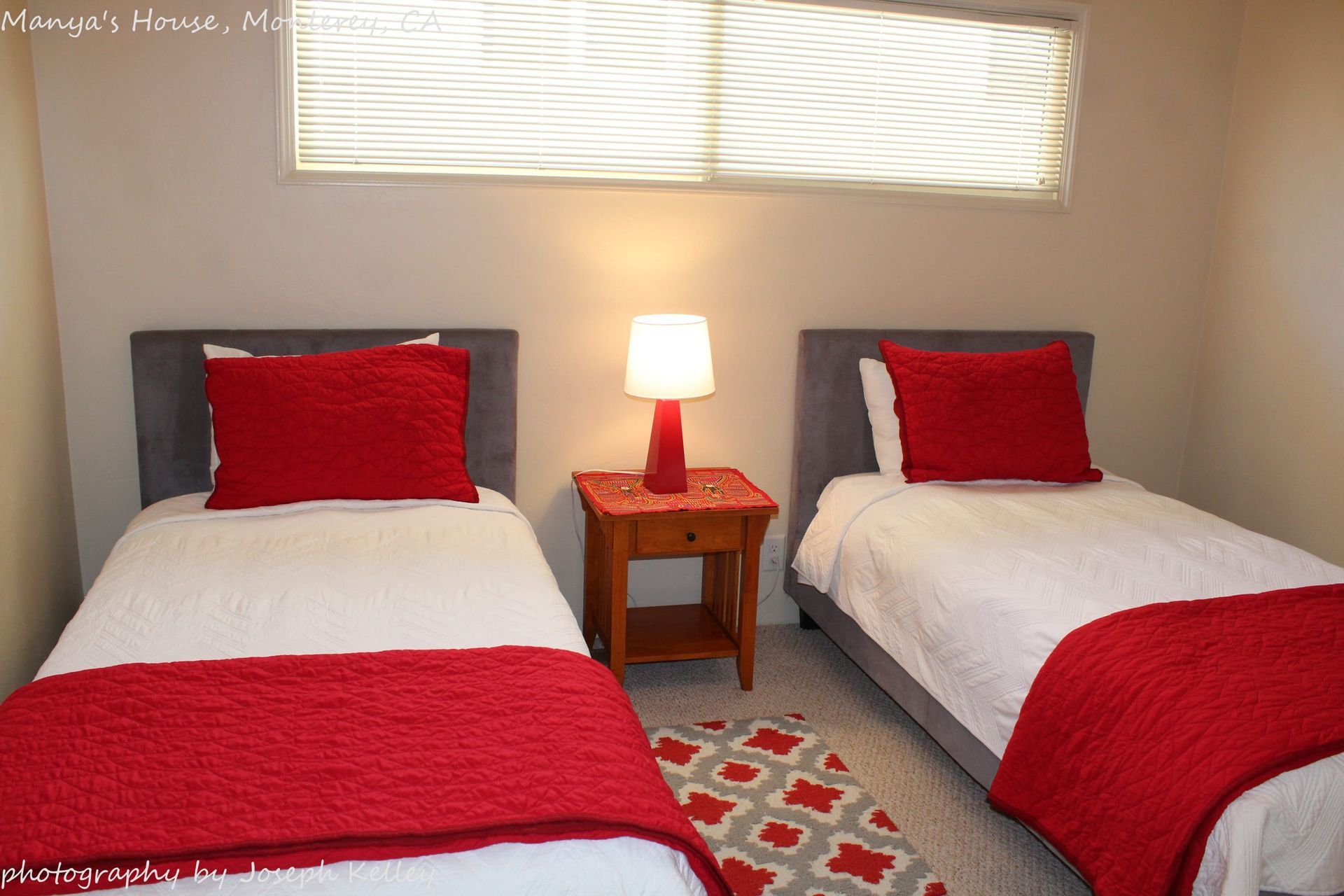 A bedroom with two twin beds and a lamp