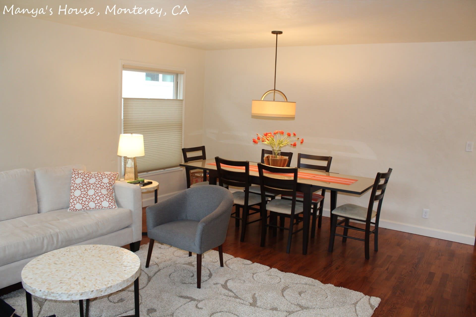 A living room with a couch and chairs and a dining table