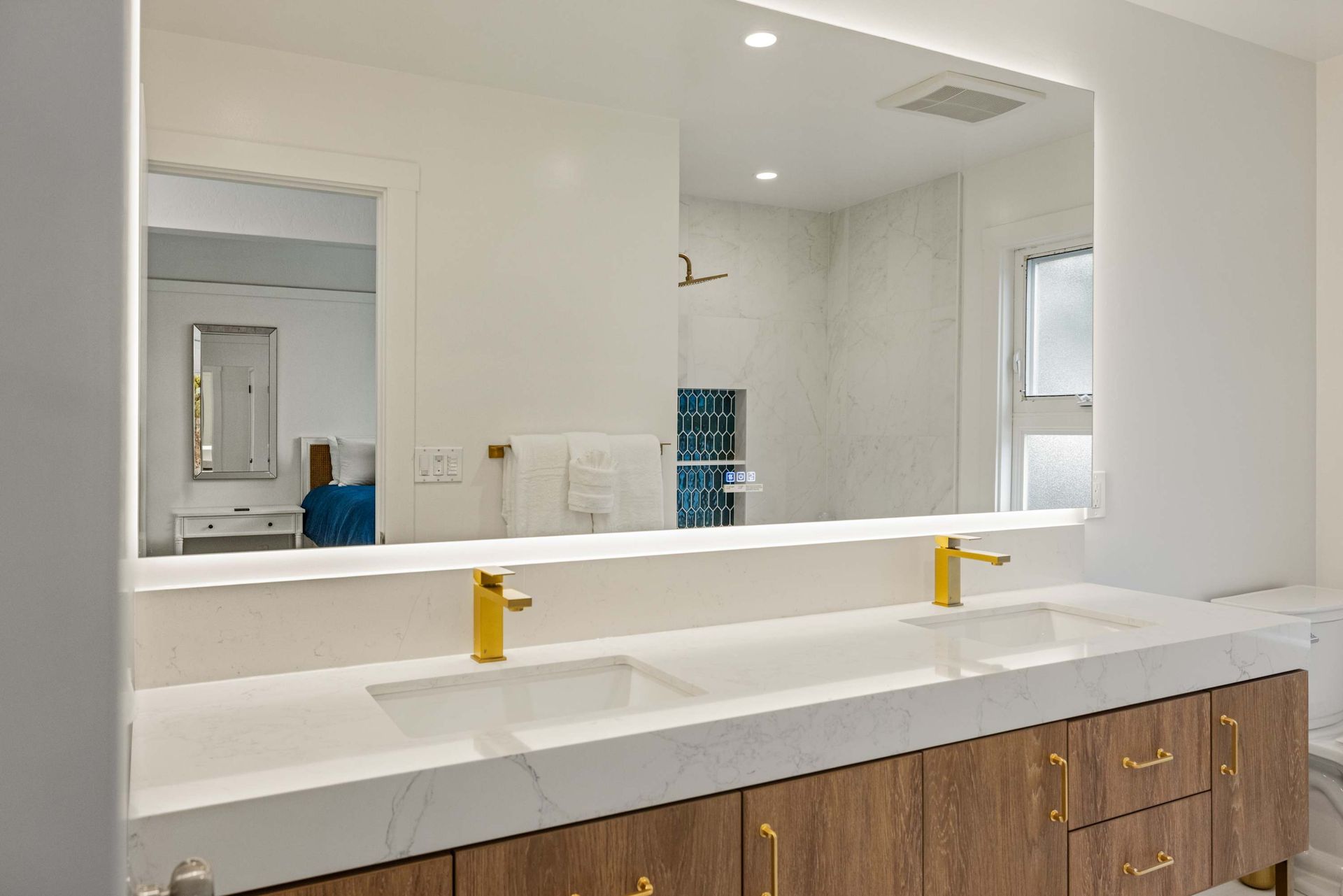 A bathroom with two sinks and a large mirror.