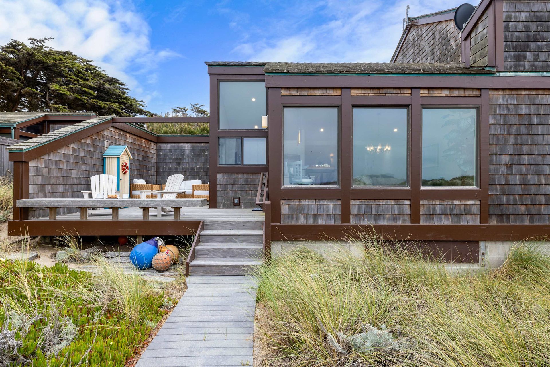 A house with a lot of windows and a walkway leading to it.