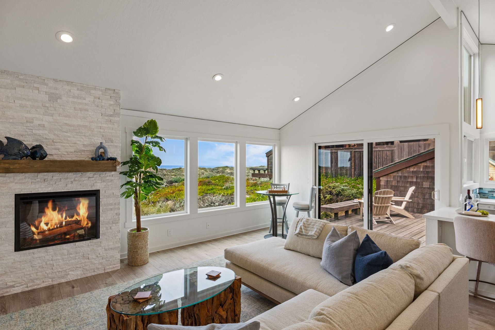 A living room with a couch , fireplace , and lots of windows.