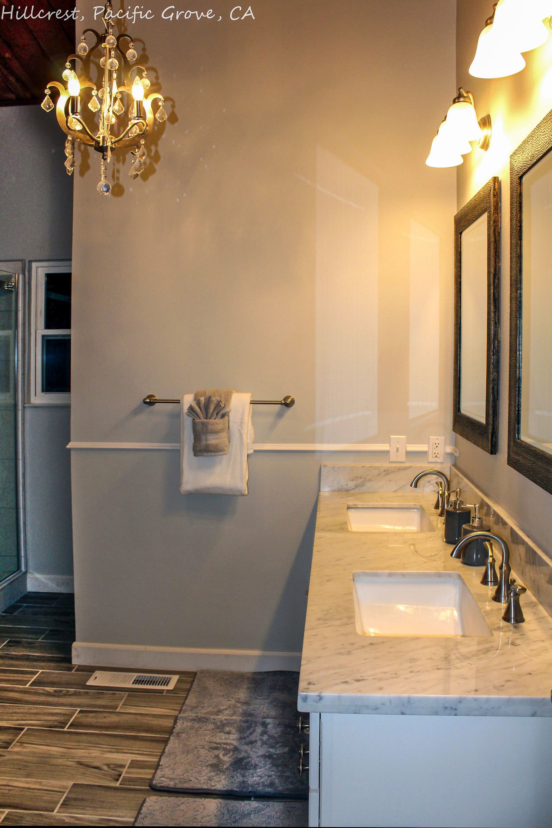 A bathroom with two sinks and a chandelier hanging from the ceiling