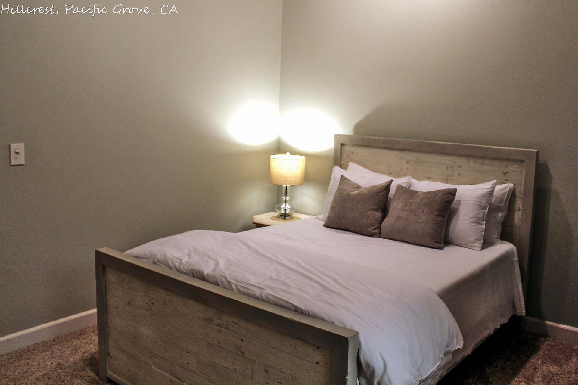 A bedroom with a large bed and a lamp