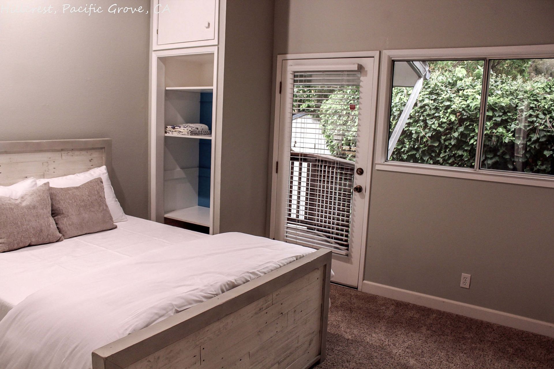 A bedroom with a bed and a sliding glass door leading to a balcony.