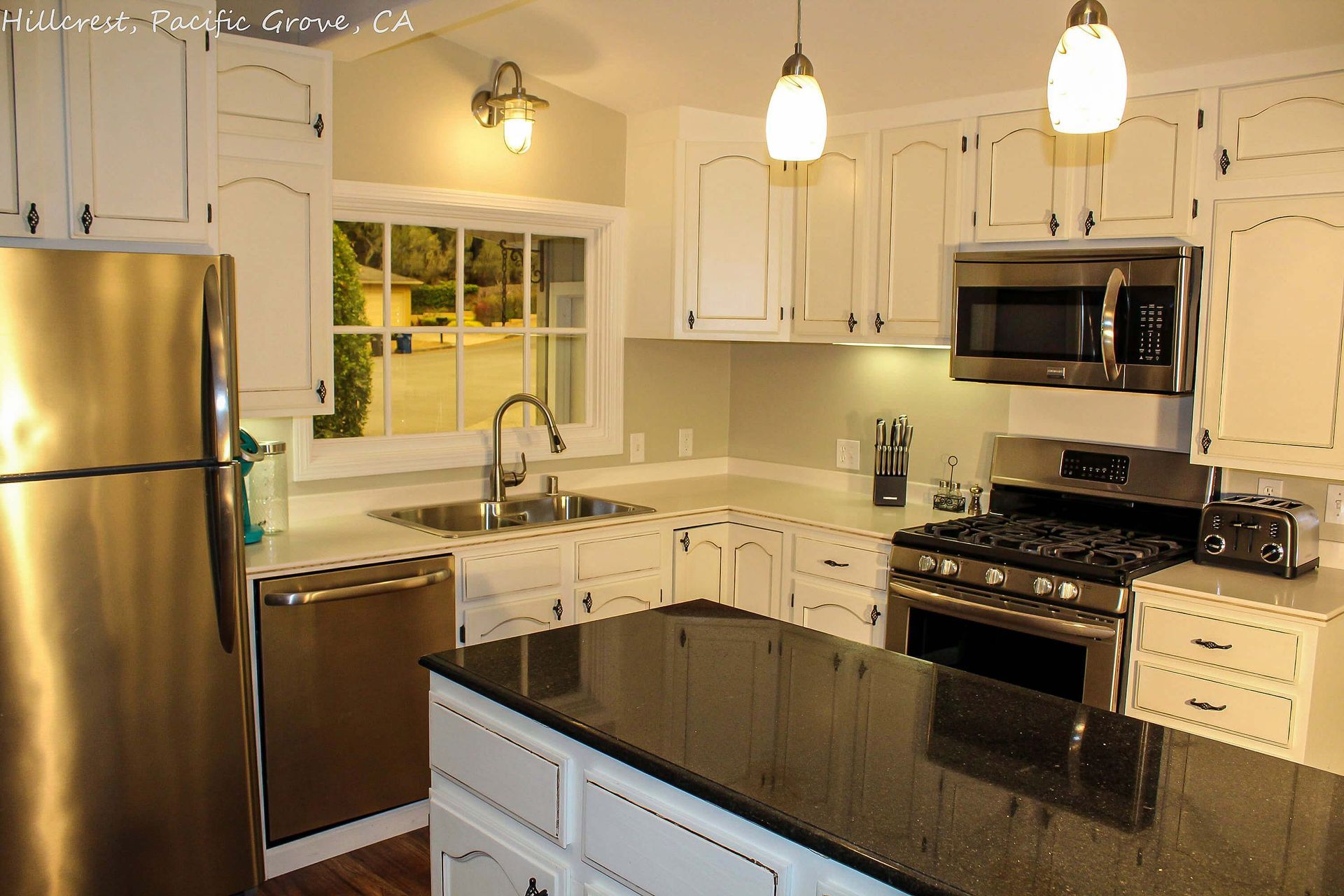 A house with a brick driveway and trees in front of it