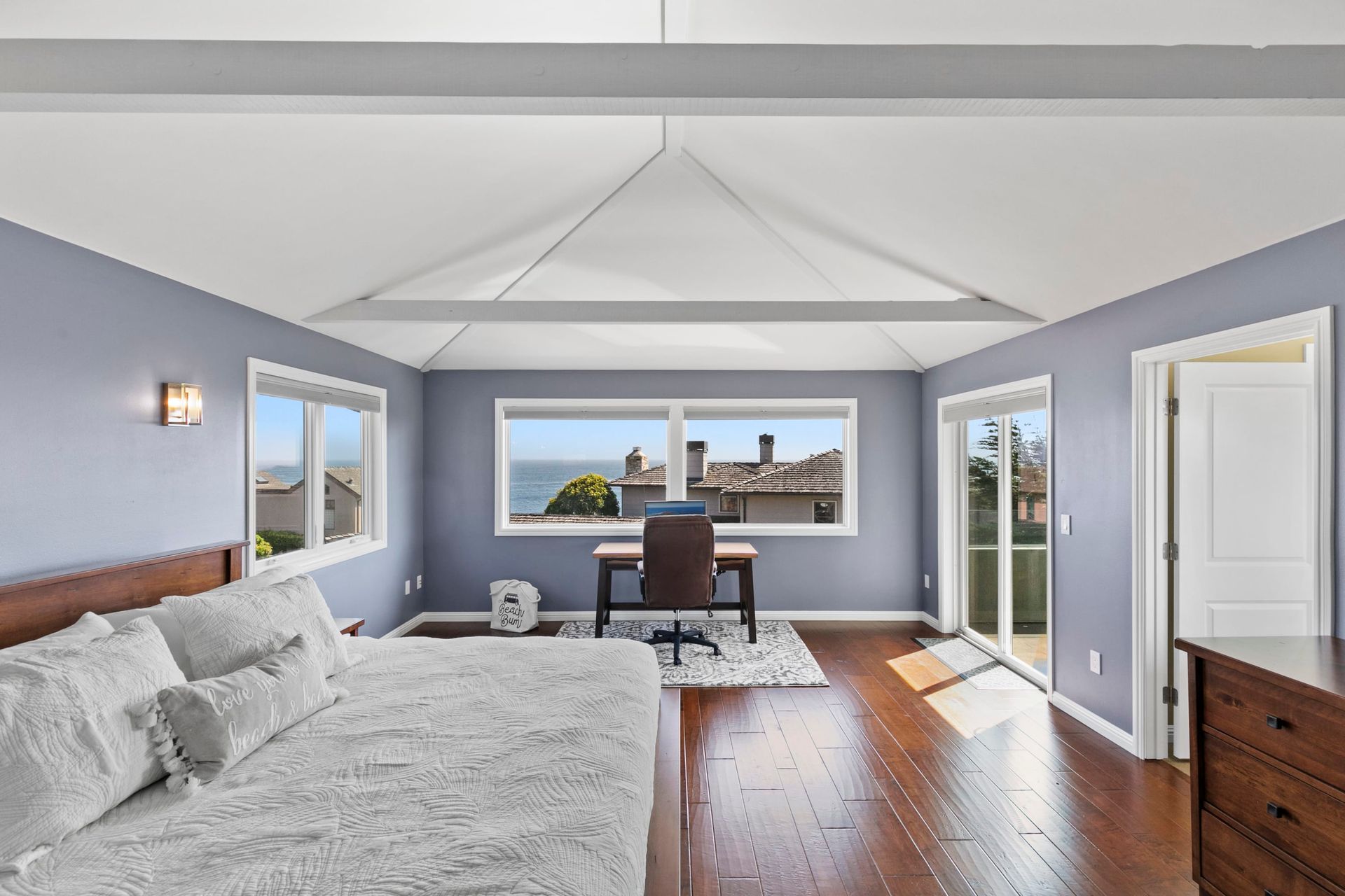 A bedroom with a large bed and a desk