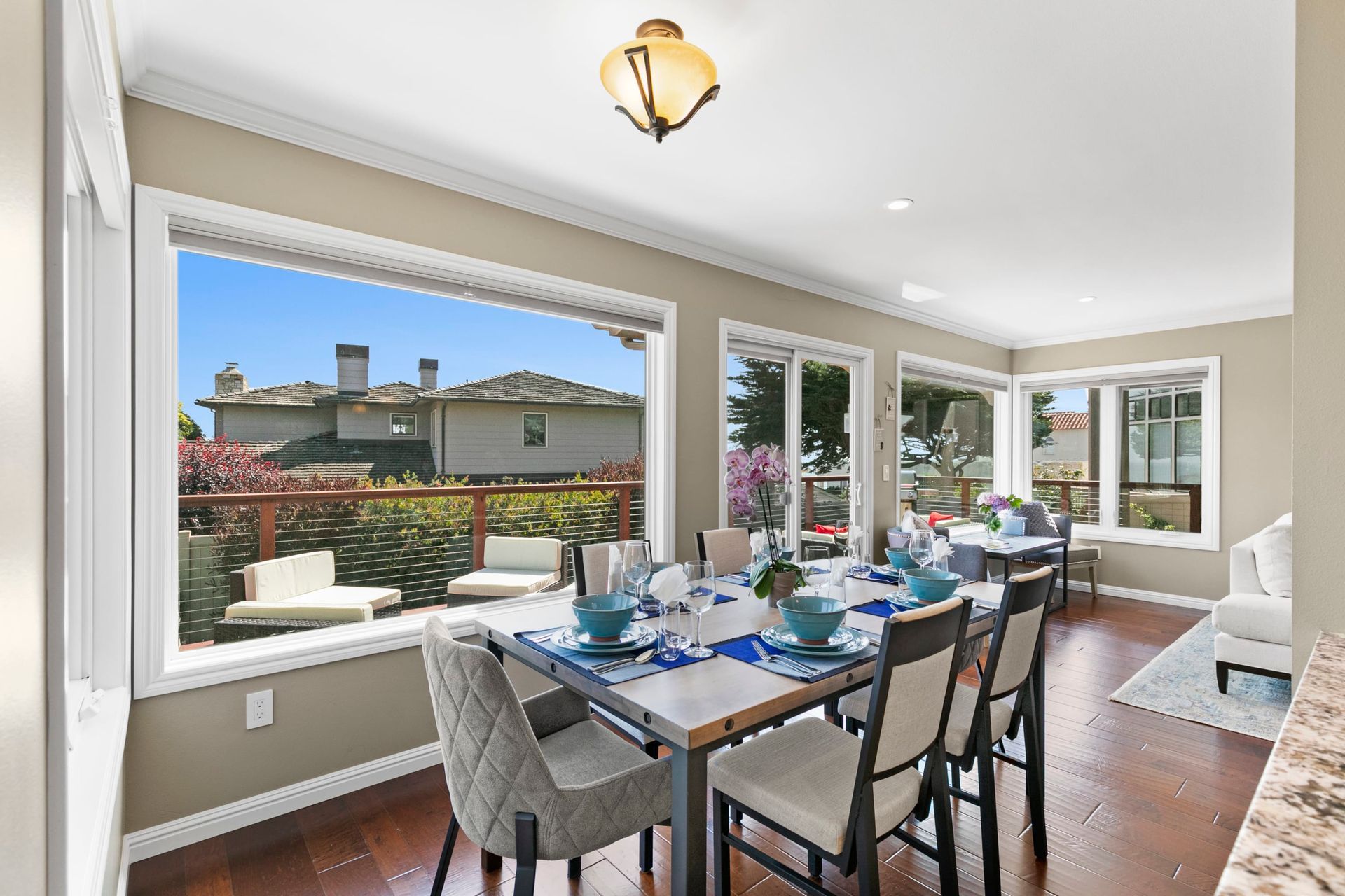 A dining room with a table and chairs and a large window.