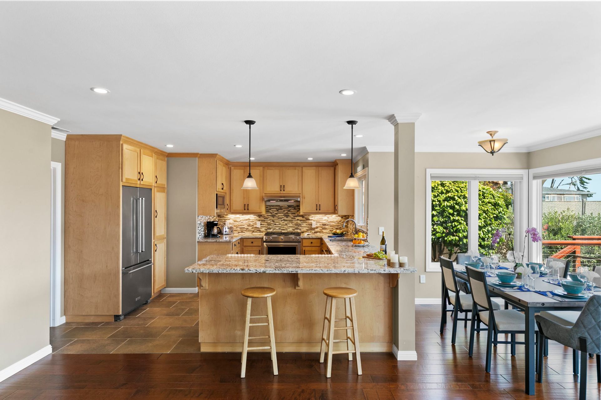 A kitchen with a large island and a dining room with a table and chairs.