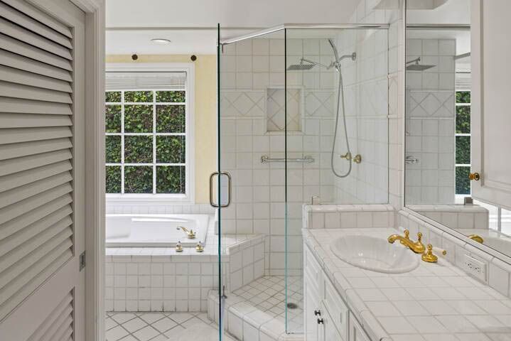 A bathroom with a walk in shower , sink , and mirror.