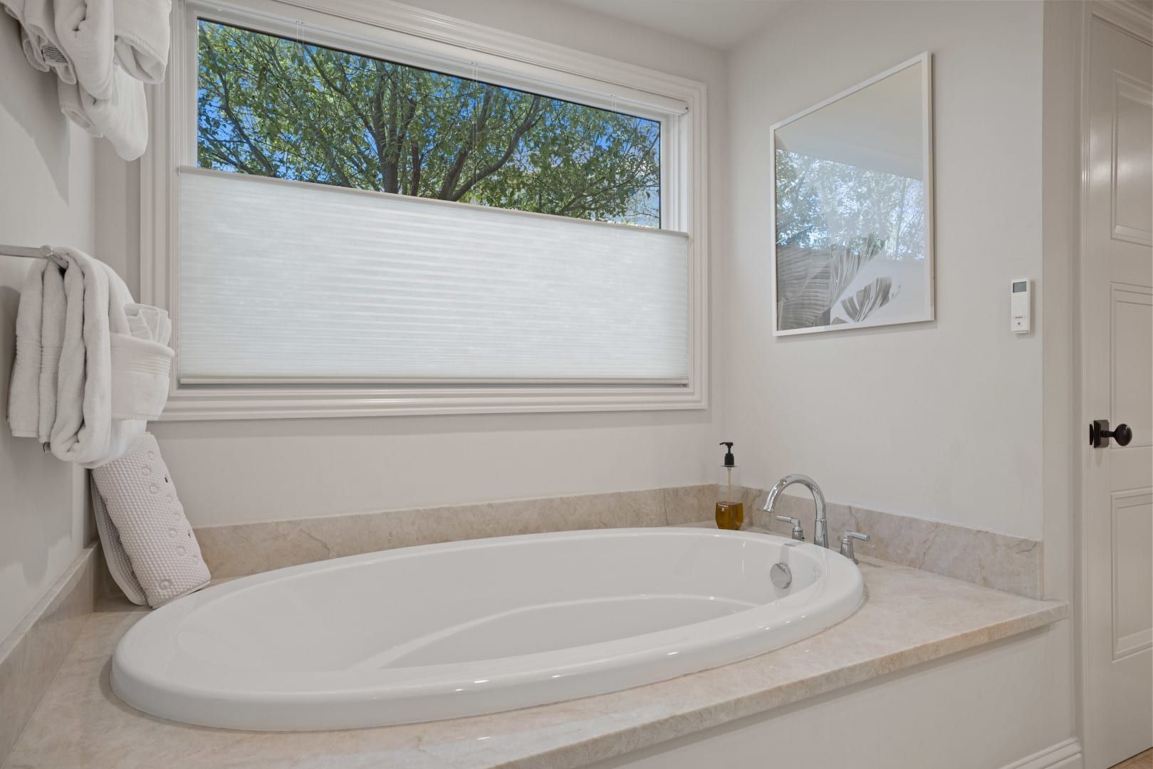A bathroom with a jacuzzi tub and a window.