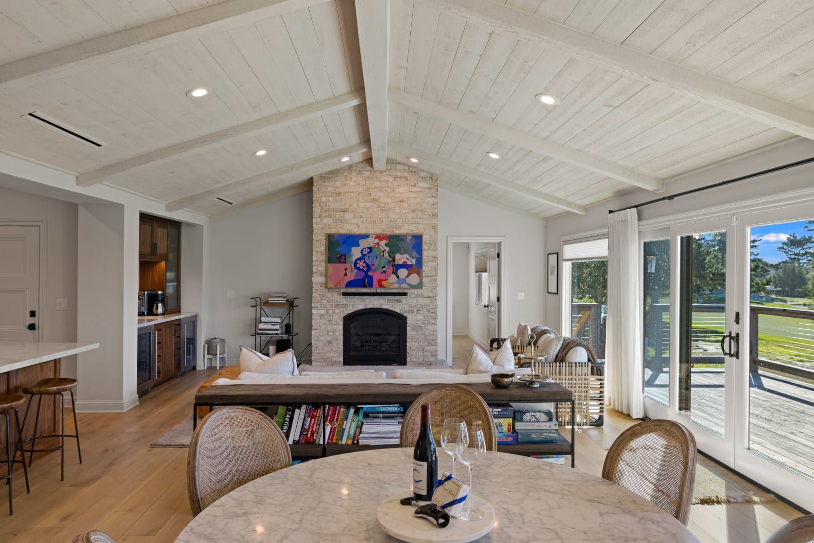 A living room with a dining table and chairs and a fireplace.