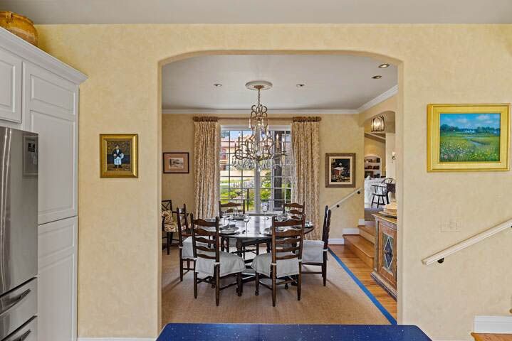 A dining room with a table and chairs and a chandelier.