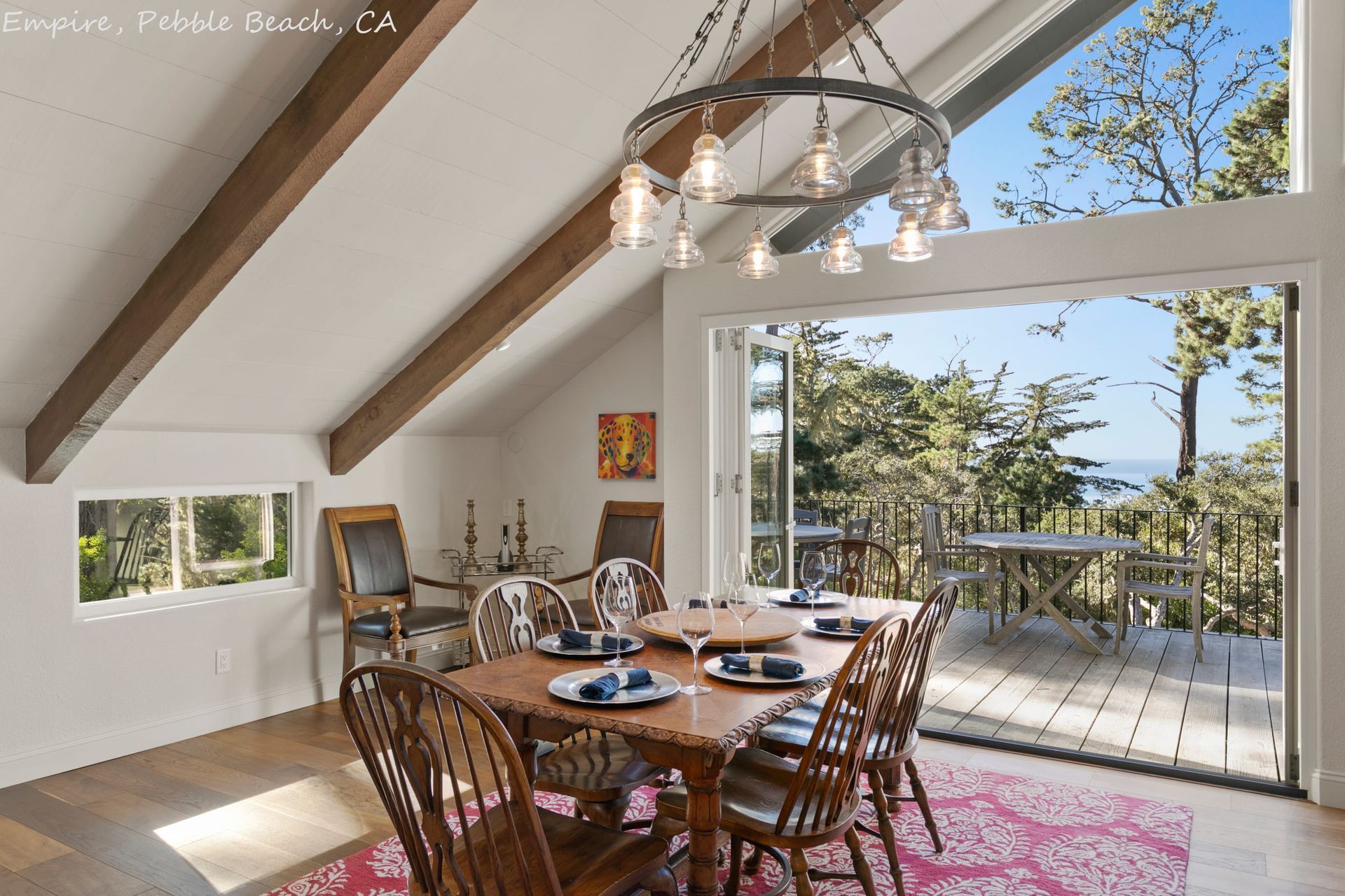 A dining room with a table and chairs and a view of the ocean