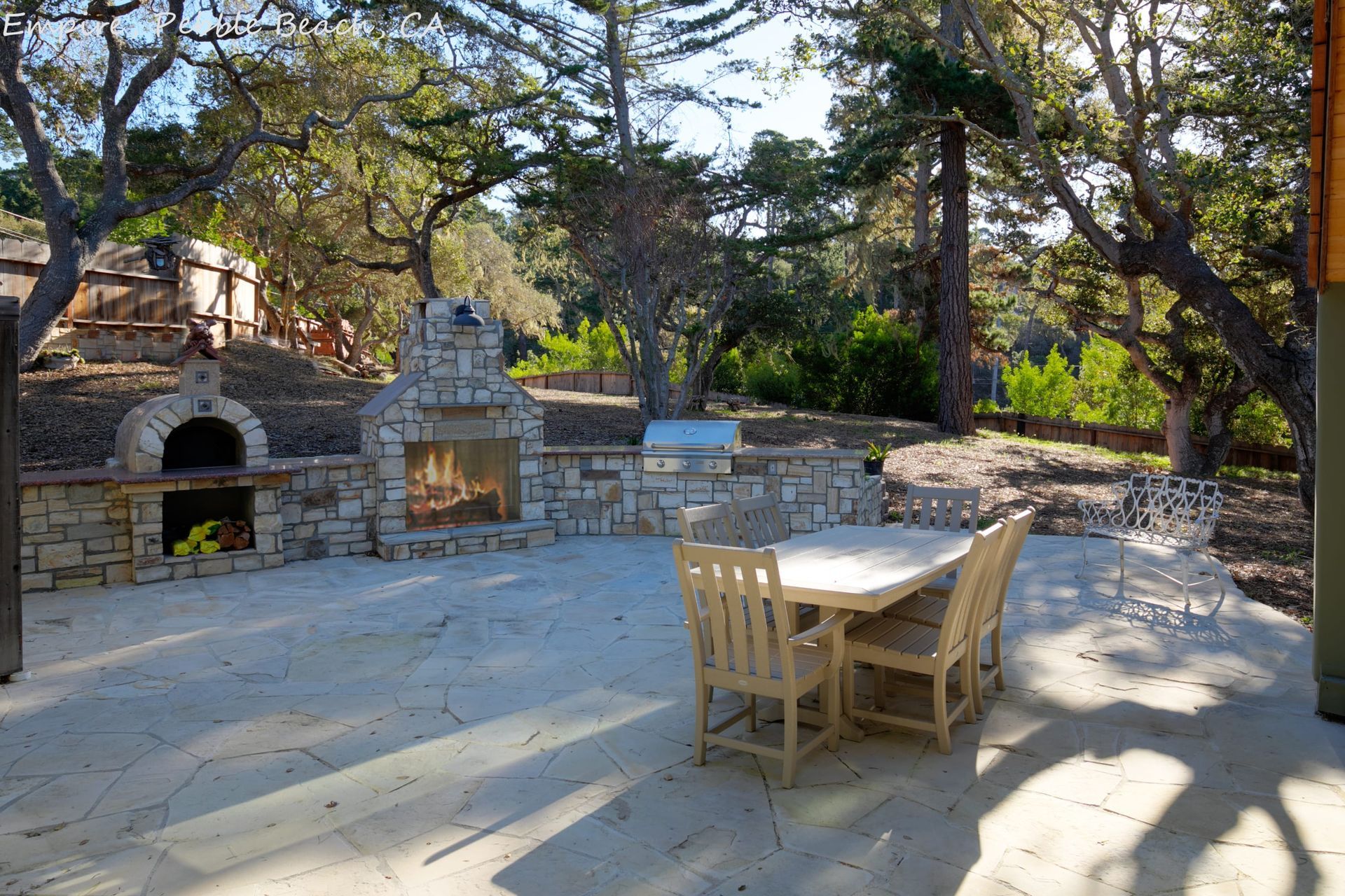 A patio with a table and chairs and a fireplace