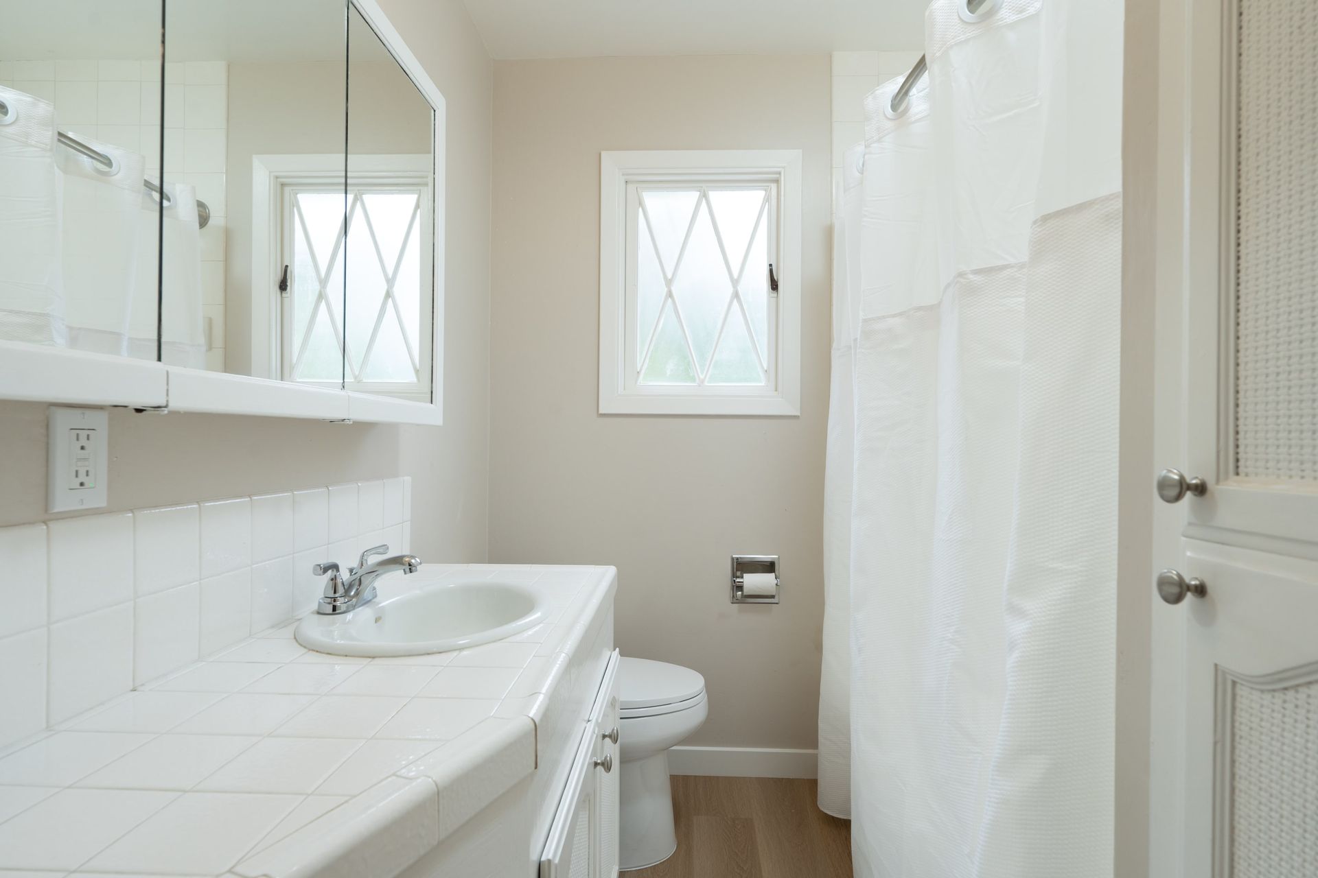 A bathroom with a sink , toilet and shower curtain.