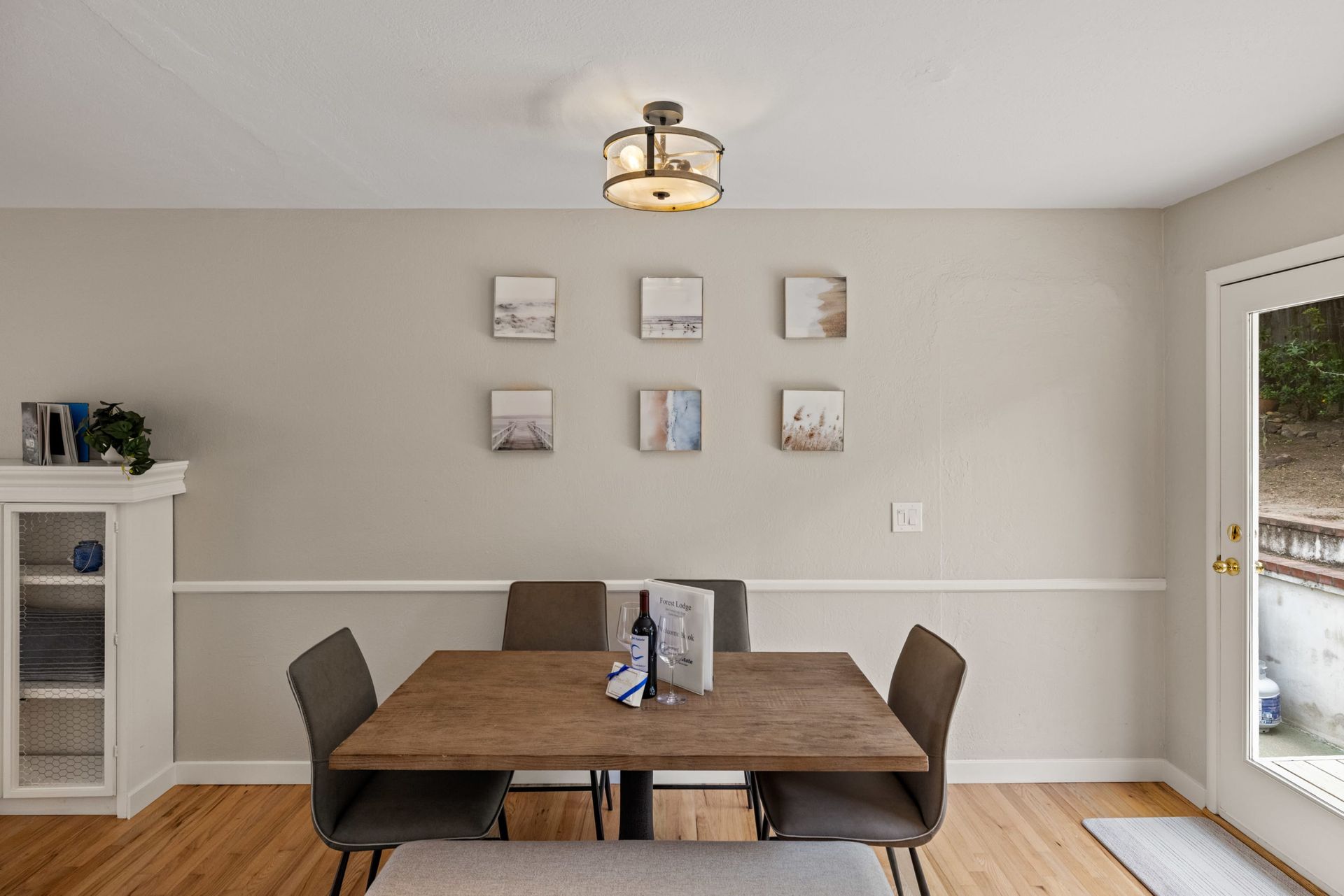 A dining room with a wooden table and chairs and a sliding glass door.