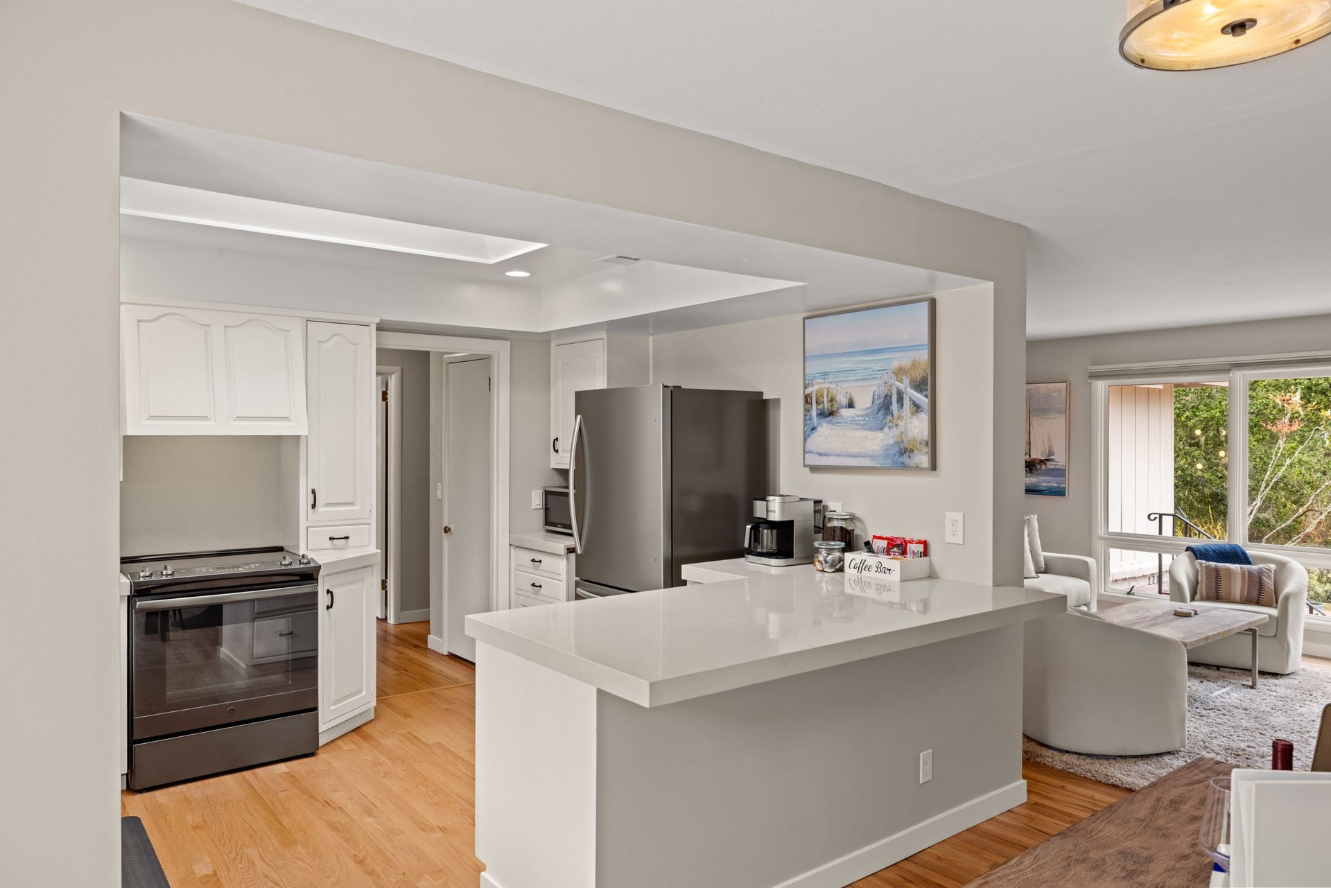 A kitchen with a stove , refrigerator , and sink.