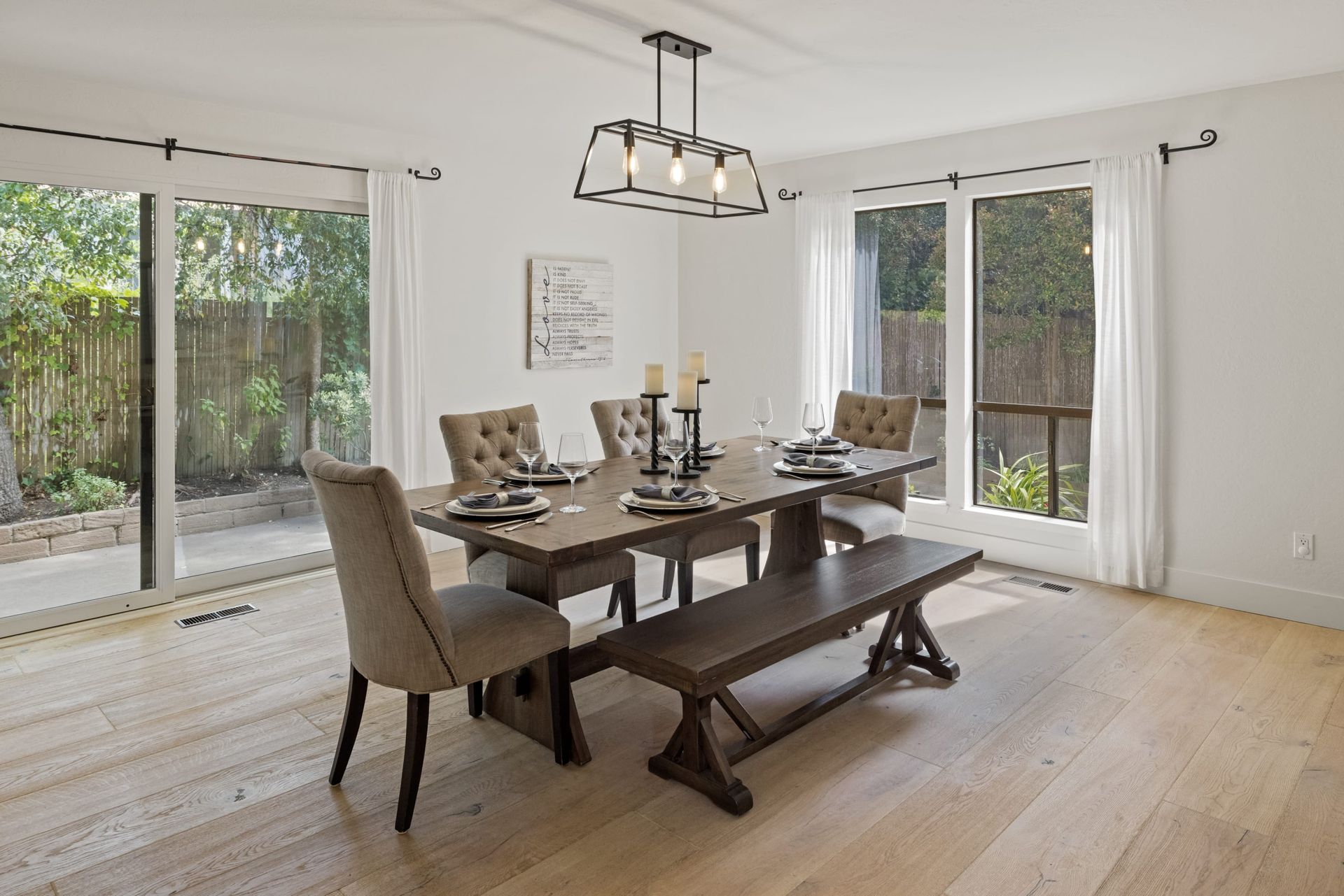 A dining room with a table and chairs and a bench.