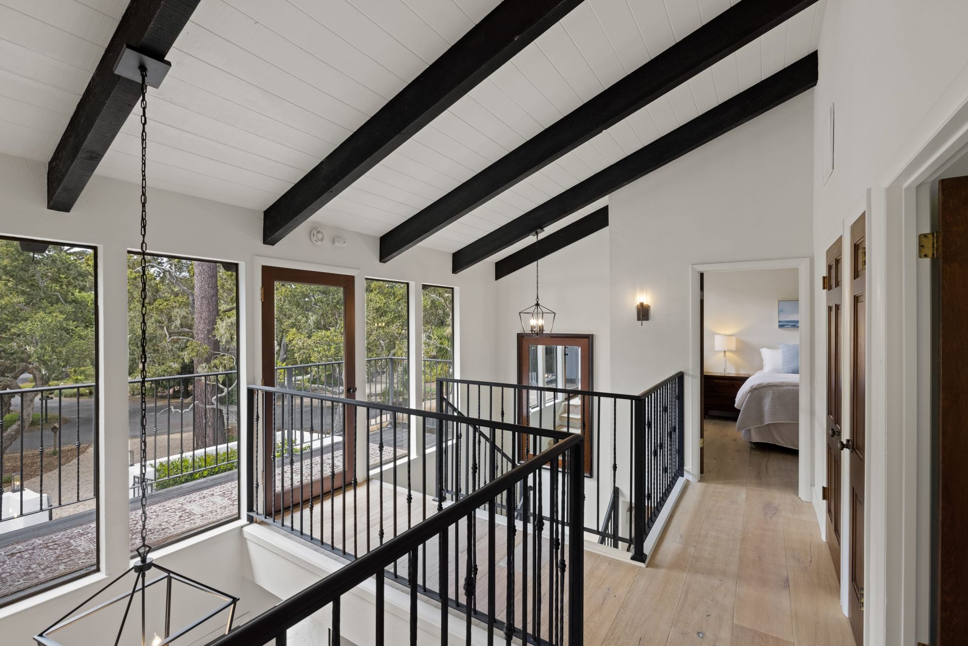 A staircase in a house with a black railing and lots of windows