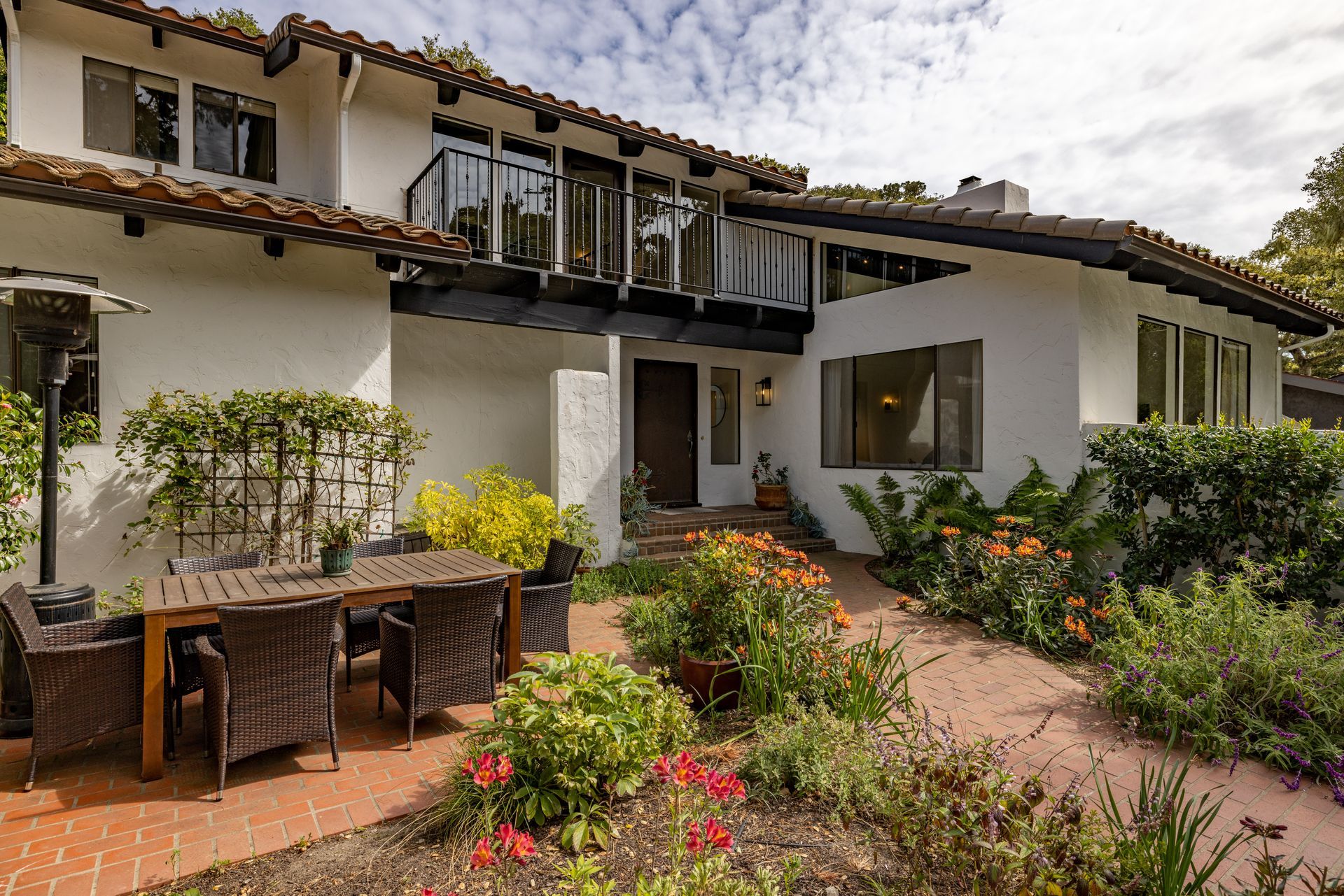A large white house with a patio area with a table and chairs