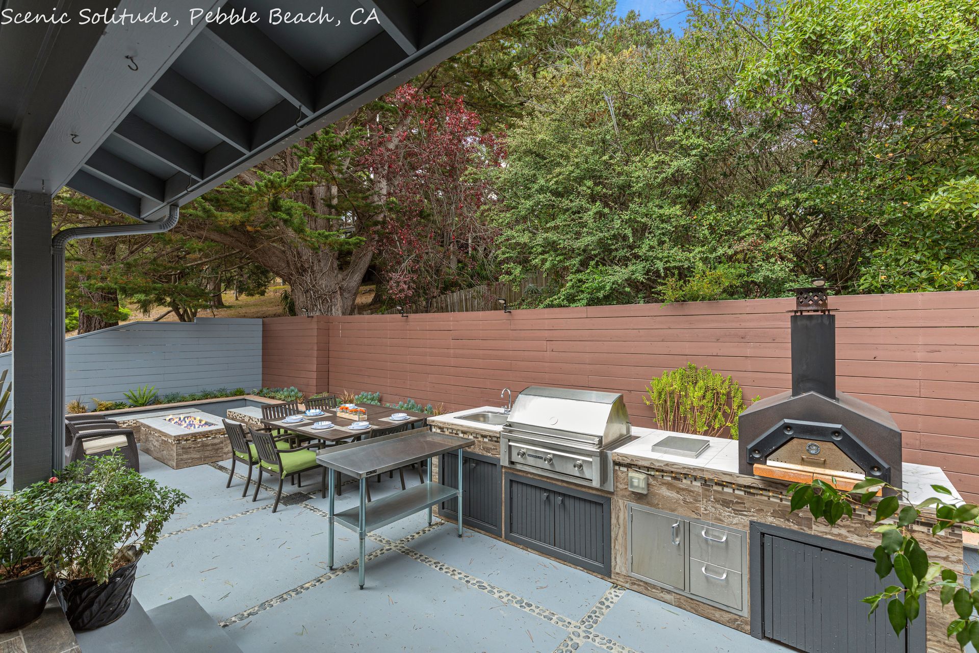 A large outdoor kitchen with a pizza oven and a grill