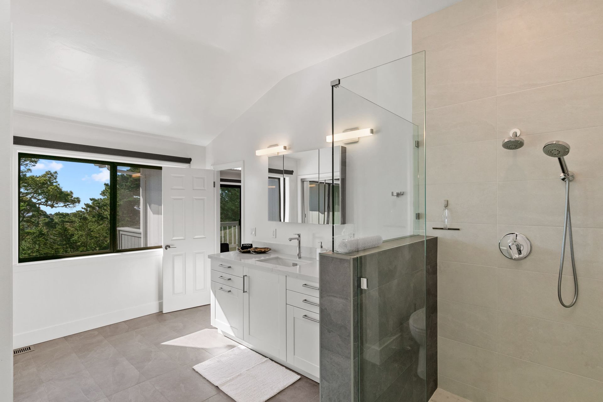 A bathroom with two sinks and a walk in shower.