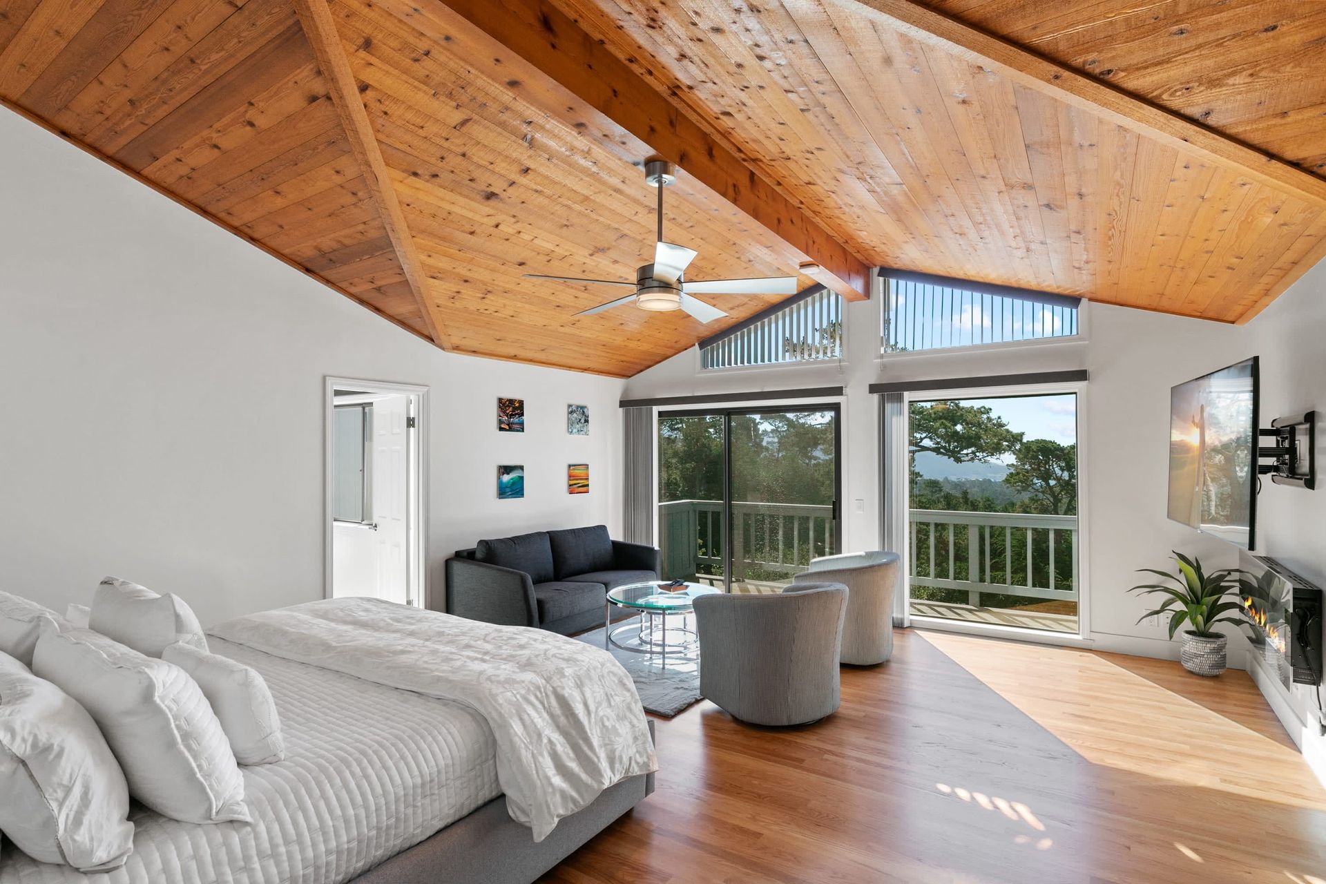 A bedroom with a king size bed , a couch , chairs and a television.