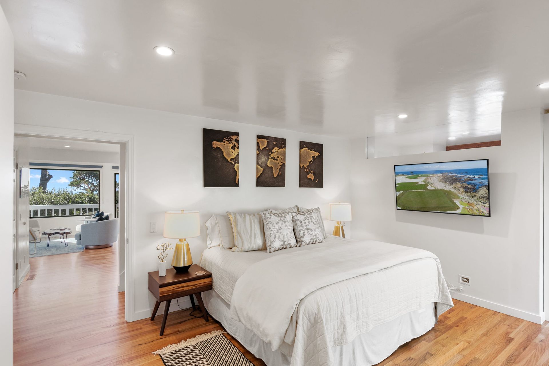A bedroom with a large bed and a flat screen tv on the wall.