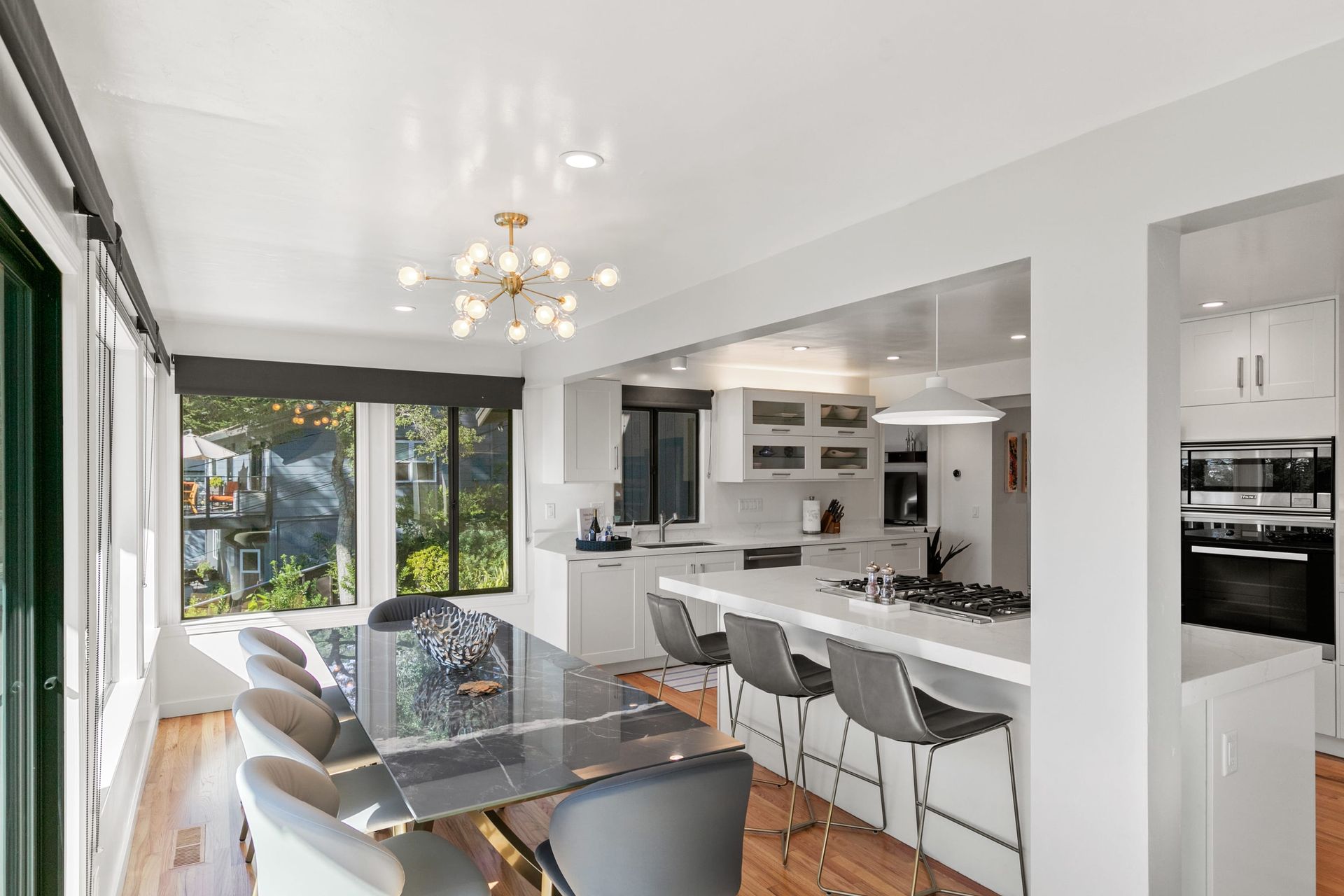 A kitchen and dining room in a house with a large table and chairs.