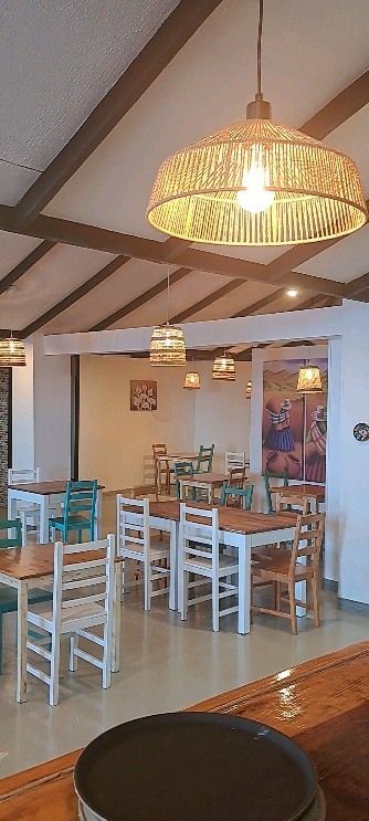 Un restaurante con mesas y sillas y una bandeja en el mostrador.